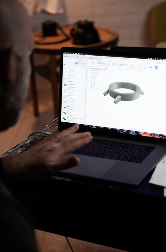 Man from behind working on a drawing of a watch on a computer