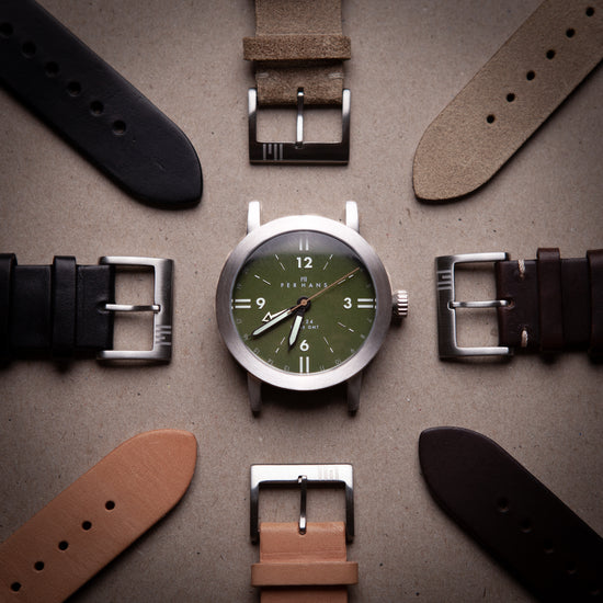 Green dial watch in center with different types of leather watch straps around it
