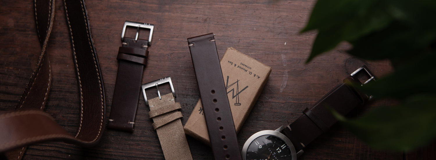 Different leather watch straps on wood table